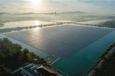  ?? VINCENT THIAN/AP ?? The sun rises over floating solar panels May 3 in Selangor, Malaysia. Floating solar panels are catching on in the U.S., too.