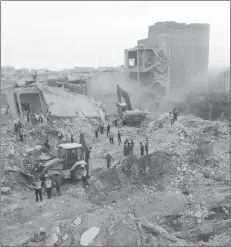  ?? SYRIAN CIVIL DEFENCE WHITE HELMETS VIA AP ?? Civil defence workers and civilians inspecting damaged buildings after airstrikes hit in the village of Zardana, in Idlib province, Syria.