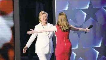  ??  ?? Ms. Clinton is welcomed onto the stage Thursday night by her daughter, Chelsea.