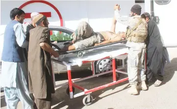  ??  ?? Afghan security forces members carry an injured policeman to a hospital after a blast in Helmand, Afghanista­n. — Reuters photo