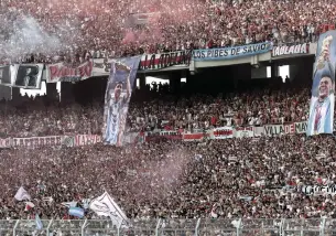  ?? AFP/ALEJANDRO PAGNI ?? Banners depicting Argentina’s German Pezzella, Lionel Messi and Enzo Fernández lifting the World Cup trophy are displayed from the stands as supporters of River Plate cheer for their team at El Monumental last Sunday.