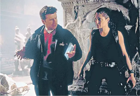  ??  ?? i Simon West and Angelina Jolie on the set of Lara Croft: Tomb Raider in 2001