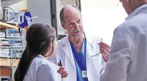  ??  ?? Dr. Alan Flake, centre, a fetal surgeon at the Children’s Hospital of Philadelph­ia, is leading a team developing a “Biobag,” or artificial womblike device, to help keep babies born severely premature alive.