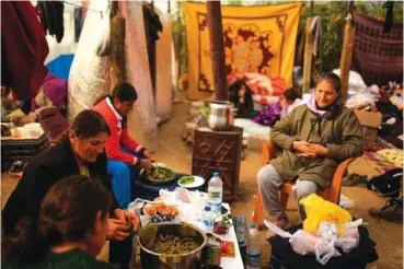  ?? AP PHOTO/FRANCISCO SECO ?? Women prepare a meal Thursday inside a greenhouse where they stay with their relatives following the earthquake in Samandag, southern Turkey.