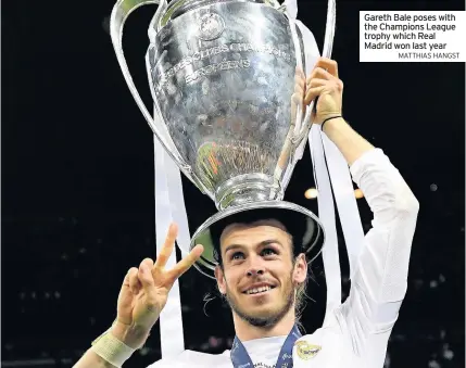  ?? MATTHIAS HANGST ?? Gareth Bale poses with the Champions League trophy which Real Madrid won last year