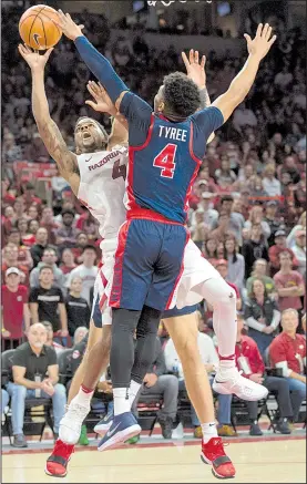  ?? NWA Democrat-Gazette/CHARLIE KAIJO ?? Arkansas guard Daryl Macon (left) gets off a shot as he is defended by Mississipp­i’s Breein Tyree during the Razorbacks’ victory Saturday at Walton Arena in Fayettevil­le. Macon had 20 points and six assists off the bench for the Razorbacks.