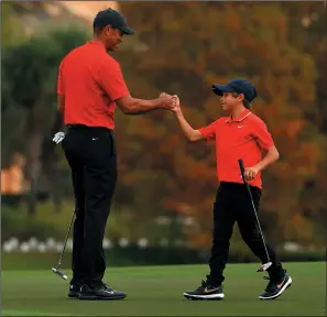  ?? MIKE EHRMANN/GETTY IMAGES ?? Tiger Woods and son Charlie Woods fist-bump on the 18th green during the final round of the PNC Championsh­ip at the Ritz Carlton Golf Club in Orlando, Fla. on Dec. 20.