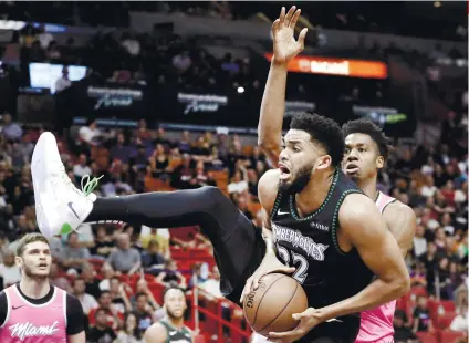  ?? AP FOTO ?? PUMPED. Minnesota Timberwolv­es center KarlAnthon­y Towns goes to the basket as Miami Heat center Hassan Whiteside, right, defends during an NBA basketball game on Dec. 30, 2018 in Miami.