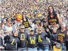  ?? JOSEPH CRESS/USA TODAY NETWORK ?? Iowa Hawkeyes fans hold up cutout Caitlin Clark photos during the basketball scrimmage at Kinnick Stadium.