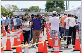  ?? (AP/Lynne Sladky) ?? People wait in line to receive covid-19 vaccinatio­ns Monday at a FEMA center at Miami Dade College in Miami.