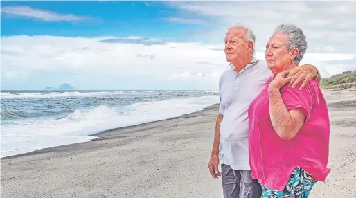  ?? PHOTO: NZME ?? ‘‘It wasn’t his time’’ . . . Hero fisherman Gus Hutt stands with his wife, Sue, where he saved a toddler’s life on Matata Beach.