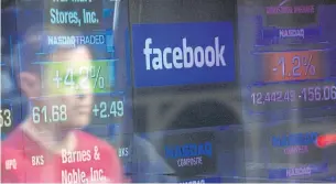  ?? AFP ?? In this file photo taken on May 17, 2012 a Facebook logo is seen through the windows of the Nasdaq stock exchange as people walk by in Times Square.