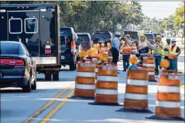  ?? ALLEN EYESTONE / THE PALM BEACH POST ?? Constructi­on workers on Kirk Road record President Donald J. Trump’s motorcade as it makes its way from Mar-a-Lago to Trump Internatio­nal Golf Club on Friday morning in suburban West Palm Beach.