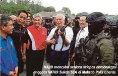  ??  ?? NAJIB mencuba senjata selepas demonstras­i anggota VAT69 Sukan SEA di Maktab Polis Cheras.