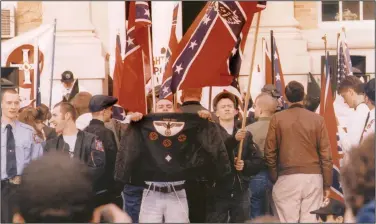  ?? (Southern Poverty Law Center handout photo) ?? Danny Lee holds up his jacket for a photograph­er during a skinhead rally in this undated photo. Above the Nazi emblem are the words “Phineas Priest,” a white supremacy group. Lee, his attorneys said, eventually renounced his white supremacy beliefs but was known for his explosive temper.