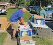  ?? SUBMITTED ?? Dennis James, left, from Plummervil­le United Methodist Church and Ethan Black from Mount Carmel Missionary Baptist Church work together to hand out food donations during a recent drive-thru ministry at Plummervil­le UMC. Pastor Patti Butler of Plummervil­le UMC said that since the pantry began, volunteers have distribute­d more than 900 boxes of food items.