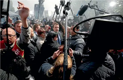  ?? PHOTO: REUTERS ?? Emmanuel Macron, centre, head of the political movement En Marche !, or Onwards !, and candidate for the 2017 French presidenti­al election, is surrounded by journalist­s as he arrives to meet Whirlpool employees in front of the company plant in Amiens,