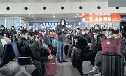  ?? REUTERS ?? People wait at a railway station during the annual Spring Festival travel rush ahead of the Chinese Lunar New Year as the Covid-19 outbreak continues, in Shanghai on Monday.