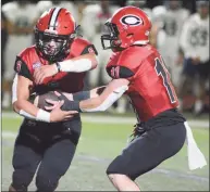  ?? Dave Phillips / For Hearst Connecticu­t Media ?? Christian Russo of Cheshire takes the handoff from quarterbac­k Mike Simeone during a football game on Friday.