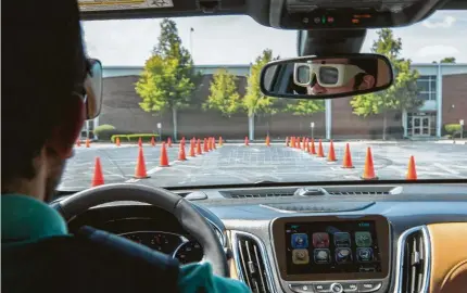  ?? Photos by Mark Mulligan / Staff photograph­er ?? Houston Chronicle writer Carlos De Loera wears glasses that simulate a state of drowsiness while driving on a closed course.