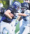  ?? Dave Stewart / Hearst Connecticu­t Media ?? Darien’s Tighe Cummiskey pounds out some rushing yards while Wilton’s Todd Woodring attempts to slow him down on Saturday in Darien.