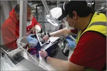  ?? AP ?? Ford Motor Co. employees work a ventilator at the Rawsonvill­e plant in Ypsilanti Township, Mich. The plant was converted into a ventilator factory as hospitals battling the coronaviru­s reported shortages.