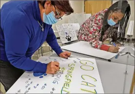  ?? BILL LACKEY PHOTOS / STAFF ?? Anna Platanioti­s (left) and Sherita Bloxom joined several other employees at the Rocking Horse Center in making signs to show their support for the Springfiel­d Wildcats.