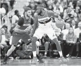  ?? NICK WASS/ASSOCIATED PRESS ?? Wizards guard John Wall backs down Heat guard Tyler Johnson, left, last week. Wall is shooting just 11.8 percent (2-for-17) from the 3-point arc.