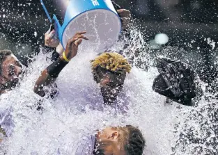  ?? DAVID ZALUBOWSKI/THE ASSOCIATED PRESS ?? The Rockies’ Charlie Blackmon, back, douses Raimel Tapia, center, after his game-winning walkoff hit Thursday against the Giants in Denver. Colorado won, 10-9.