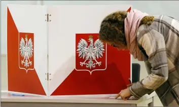  ??  ?? A woman checks her ballot paper, during the second round of at a voting station in Lomianki, Poland, on Sunday. AP PhoTo/CzArek SokolowSkI