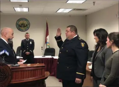  ??  ?? Troy Mayor Patrick Madden, left, swears in Assistant Police Chief Christophe­r Kehn on Tuesday morning as Kehn’s wife, Ginger, and daughter, Emily, look on
