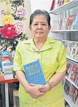  ?? YASUSHI UKIGAYA ?? The novelist holds one of her classic works, ‘Jod Mai Jak Muang Thai’ (Letters from Thailand).