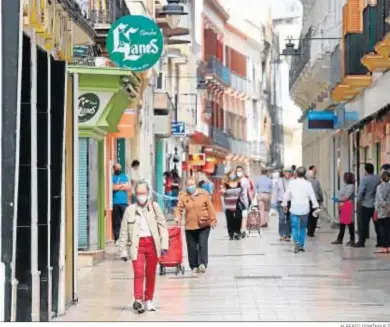  ?? ALBERTO DOMÍNGUEZ ?? Los onubenses pasean por una calle céntrica durante la fase 0 del desconfina­miento.