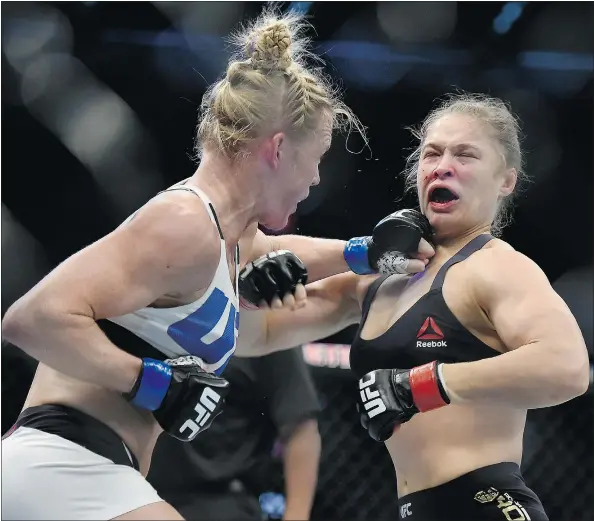  ?? — PHOTOS: THE ASSOCIATED PRESS FILES ?? Holly Holm, left, lands a punch to Ronda Rousey’s chin during their UFC 193 bantamweig­ht title fight in Melbourne. Holm pulled off a stunning upset with a powerful kick to the head 60 seconds into the second round.