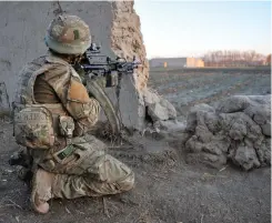  ?? ?? ■ Right: A soldier of the 1st Battalion, the Yorkshire Regiment observing a suspect insurgent compound whilst on patrol in the Nahr-e Saraj district of Helmand Province. During this tour 1 Yorks were stationed at PB (Patrol Base) Rahim to the north of Gereshk, the same PB from which the assault of 13 June 2012 was launched. (© Crown Copyright 2013)