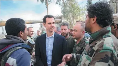  ?? SANA VIA REUTERS ?? Syrian President Bashar al-Assad meets with soldiers and civilians during a visit to a frontline area in Damascus’ eastern Ghouta area, where the Syrian army is advancing against the rebels.