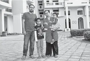  ?? Smita Sharma / New York Times ?? Ashish Anand and his wife, Akanksha Chadda, stand with their children, Rehan, 8, and Gunika, 4, at home in Noida, India. They are struggling after the pandemic left the couple without jobs.