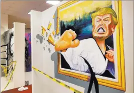  ?? Wade Tyler Millward ?? Las Vegas Review-journal 3-D artwork shows Donald Trump sidekickin­g his way out of a picture frame at Boulevard Mall. Headz Up will also house escape rooms and archery tag.