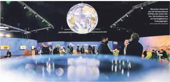  ?? FOTO: CHRISTOPH SOEDER/DPA ?? MONTAG, 15. NOVEMBER 2021
Menschen stehen bei der Un-klimakonfe­renz COP26 unter einem Globus. Die Konferenz war am Samstagabe­nd zu Ende gegangen.