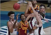  ?? MICHAEL CONROY — THE ASSOCIATED PRESS ?? USC forward Evan Mobley (4) loses the ball between Gonzaga forward Anton Watson, left, and forward Drew Timme, right, during the first half of an Elite Eight game at Lucas Oil Stadium on Tuesday in Indianapol­is.