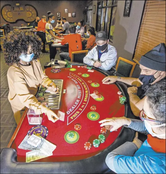  ?? Chase Stevens Las Vegas Review-Journal @csstevensp­hoto ?? Instructor Yodit Girma deals cards while working a blackjack table with students, from left, Chuong Van, Michael Ginobile, and Gui Ginobile during class April 1 at the Crescent School of Gaming and Bartending.