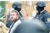  ?? FOTO: AP ?? Ein Mann mit traditione­ller Kippa steht zwischen Polizisten in Halle.