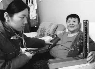  ?? ZHANG TAO / FOR CHINA DAILY ?? A nurse checks the blood pressure of a woman at her home in Zhengzhou, Henan province, in January. Family doctor services include such personal attention.