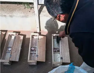  ??  ?? Desperate measures: An officer (above) from the Health Ministry setting rat traps as a measure against the plague in a primary school in Andraisoro while (right) people queue outside a pharmacy for medication and face masks in downtown Antananari­vo. —...