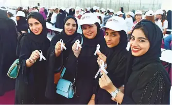  ?? Ahmed Kutty/Gulf News ?? Participan­ts holding ribbons during the cancer awareness campagin to set new Guinness world records in support of cancer awareness on Al Hudayriat Island.