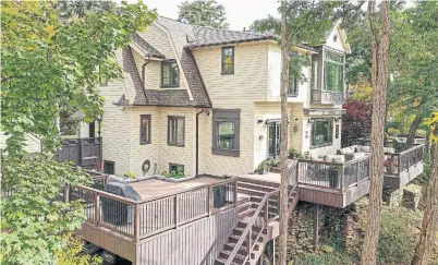  ?? UP PHOTOGRAPH­Y PHOTOS ?? The ravine backyard features two large decks off the home’s main floor and tiered stairs leading down to the shoreline.