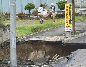  ?? AP ?? Workers remove the mud caused by ground liquefacti­on from a street (left) as residents bring out their belongings from a damaged house (above) in the Kiyota ward of Sapporo in Hokkaido yesterday, three days after a powerful earthquake jolted the area.