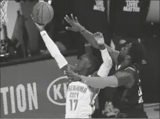  ??  ?? (17) scores against Houston Rockets’ Jeff Green (right) during the second quarter of Game 4 of a NBA first-round playoff series on Monday in Lake Buena Vista, Fla.
TIP-INS