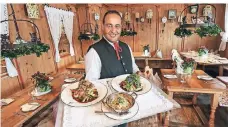  ?? FOTO: HANS-JÜRGEN BAUER ?? Ali Taouil serviert in der Dorfstube Zwiebelros­tbraten, Maultasche­n und Spätzle.