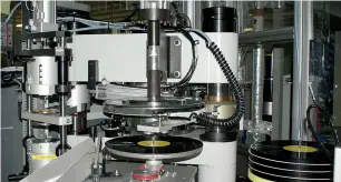  ??  ?? A press-and-trim machine of vinyl records at the Sony DADC Japan Shizuoka factory in Yoshida town. Vinyl has been making a global comeback as it attracts not only nostalgic older consumers but also younger generation­s. —